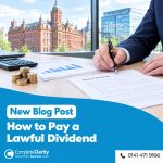 Company director signing board minutes approving a dividend, with company accounts, calculator and pound coins on the desk